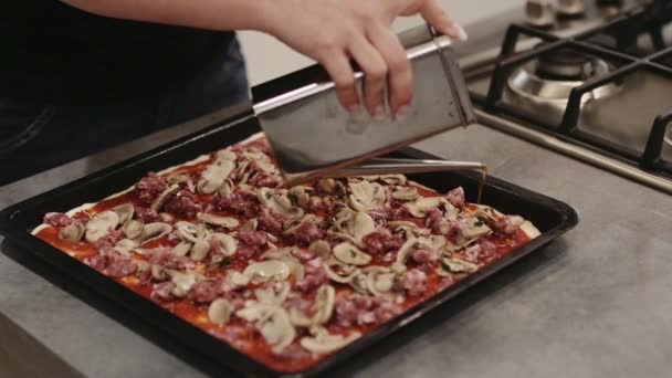 Mujer vertiendo aceite sobre pizza — Vídeo de stock