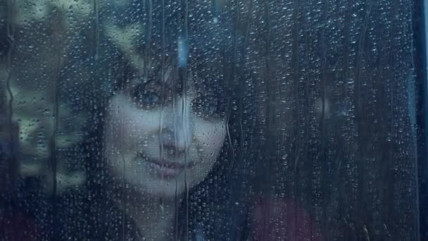 Mujer detrás de la ventana en un día lluvioso — Vídeo de stock