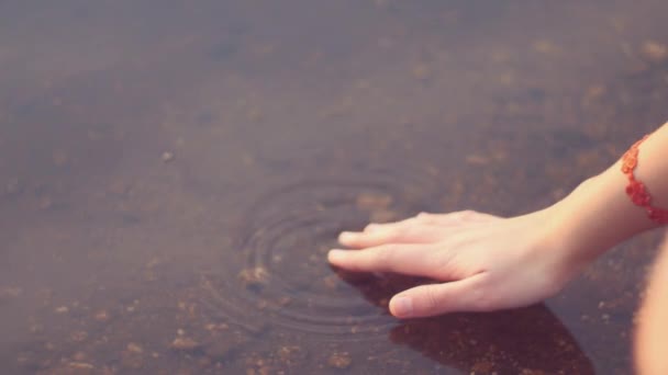 Girl hand caresses the lake water — Stock Video