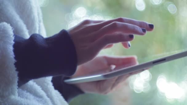 Kız bir dijital tablet kullanarak bir pencerenin yakınındaki — Stok video