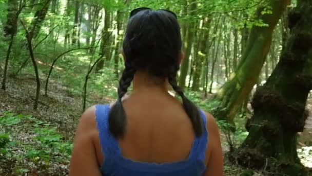 Una donna che cammina nella foresta. Girato al rallentatore — Video Stock