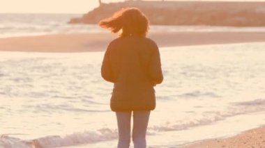 Kumsalda yürüyen kız..