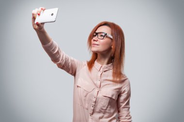 Selfie fotoğraf Smartphone'da yapma bir çekici kadın portresi gri arka plan izole