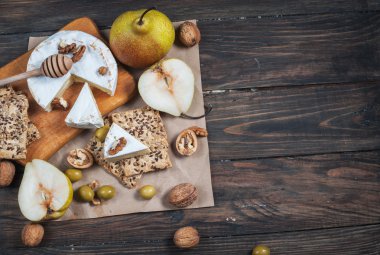 Camembert peyniri ceviz, bal ve armut rustik tablosundaki ile. Bardak beyaz şarap