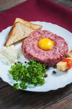 Biftek tartare ekmek ve ahşap arka plan üzerinde taze soğan ile.