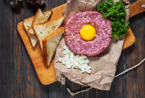 Tartare de boeuf avec pain et oignon frais sur fond de bois — Photo