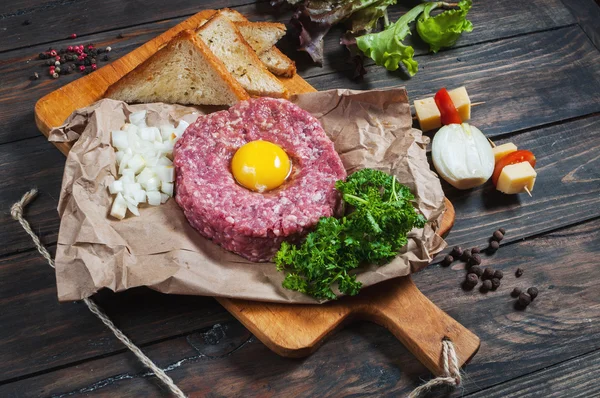 Tartare de boeuf avec pain et oignon frais sur fond de bois — Photo