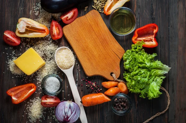 Organik vejetaryen malzemeler, zeytin yağı ve pirinç rustik ahşap kesme tahtası üzerinde arka plan üzerinde. metin, en iyi görünüm için yer — Stok fotoğraf