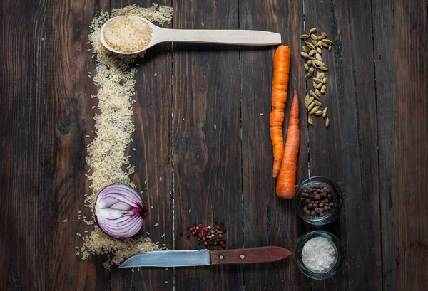 Ingredientes para cocinar arroz con verduras, un cuchillo, marco forrado sobre fondo de madera vista superior — Foto de Stock