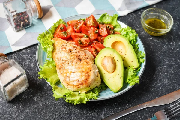 Kızarmış tavuk ve siyah taştan arka planda avokado ile Caprese yemek kasesi