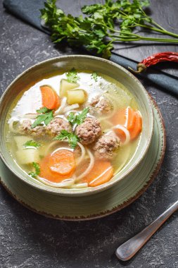 Köfte çorbası ve malzemeler taş masada..