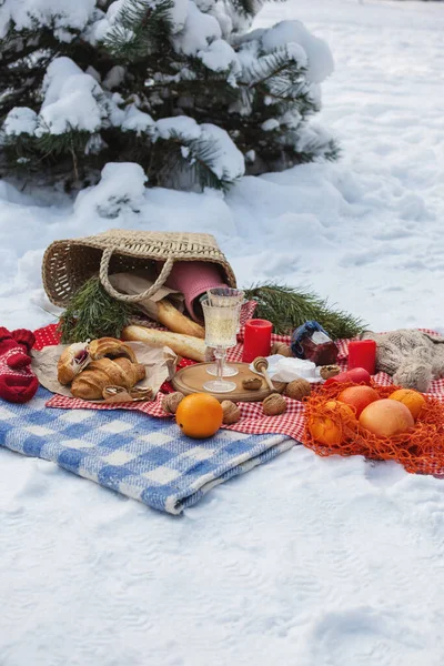 Romantyczny piknik w zimowym parku, kolorowy koc. Świeże jedzenie, ser, pomarańcze, rogaliki, wino i orzechy włoskie. Relaks na świeżym powietrzu, jedzenie na świeżym powietrzu. — Zdjęcie stockowe