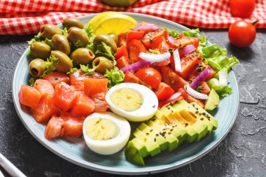 Ketogenik, paleo diyet kasesi tuzlanmış somon balığı, limon, avokado, zeytin, haşlanmış yumurta, domates, yeşil marul salatası, sağlıklı beslenme eğilimi.