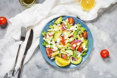 Vejetaryen sağlıklı öğle yemeği. Taze sebzeli makarna salatası. Beton arka planda avokado ve feta.