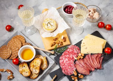 Antipasto tabağı soğuk et, ekmek, salam, dilim jambon ve peynir ile beton arka planda.