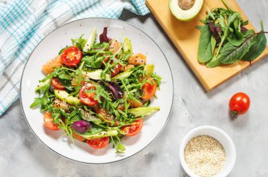 Yeşil yapraklı somon salatası, avokado ve çimento kaplı vişneli domates. Üst görünüm
