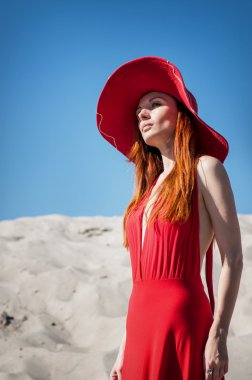 Kumsalda kırmızı elbiseli güzel bir kadın