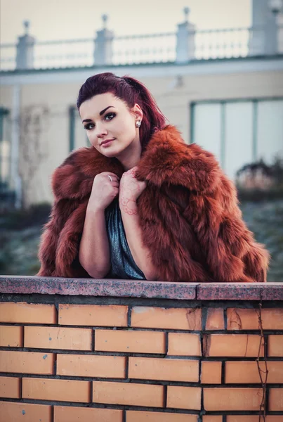 Mode photo extérieure de femme sexy glamour aux cheveux foncés portant manteau de fourrure luxueux et gants en cuir — Photo