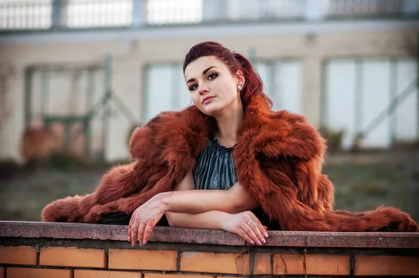 Fashion outdoor photo of sexy glamour woman with dark hair wearing luxurious fur coat and leather gloves — Stock Photo, Image