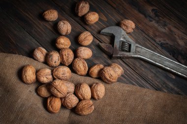 Ayarlanabilir wrenchand koyu ahşap arka plan üzerinde ceviz.