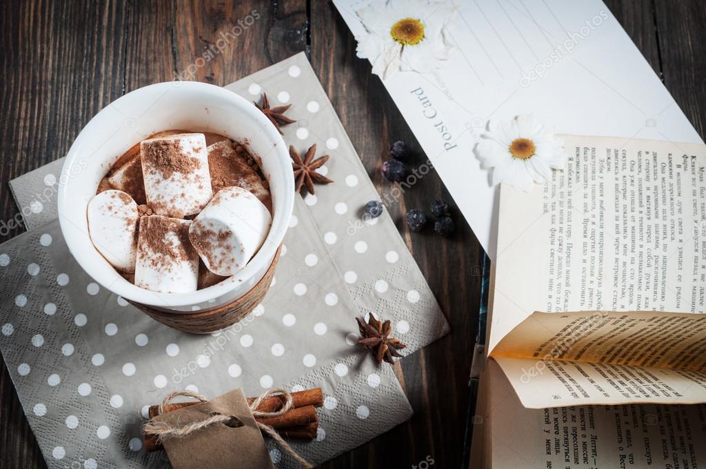 Hot chocolate drink with marshmallow and a book