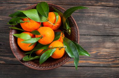 Bir kaba ahşap arka plan üzerinde olgunlaşmış taze sulu mandalina tabak. Üstten Görünüm