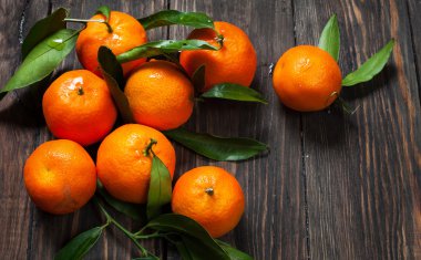 Clementine mandalina ile koyu ahşap arka plan yapraklarda