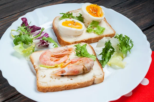 Sandwiches with shrimp, egg, basil, salad, bread on wood background. Delicious cold snacks. Vegetarian meals. Healthy eating.