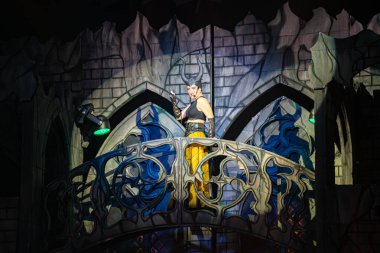 Gösteri sırasında gotik sahne balkonunda boynuz kostümlü bir sirk sanatçısı. Toronto, Kanada - 19 Ekim 2025.