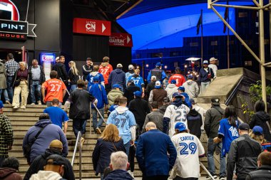 Blue Jays taraftarları gece beyzbol maçından önce Rogers Center 'a doğru yürüyorlar. Toronto, Kanada - 20 Ekim 2025.