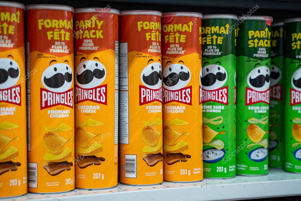 Close up of Pringles cheddar cheese and sour cream cans on store shelf. Toronto, Canada - September 18, 2025.