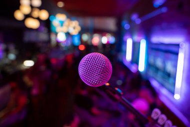 Arka planda bulanık kalabalıkla bardaki mikrofonu kapat.