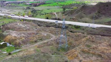 Otoyolun yanındaki yüksek voltaj hattı ve elektrik direğinin havadan görüntüsü.