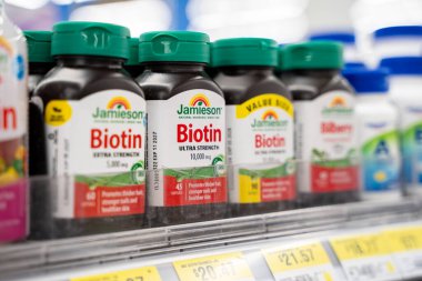 Mağaza rafındaki Jamieson biotin takviye şişelerini kapat. Toronto, Kanada - 26 Kasım 2025.
