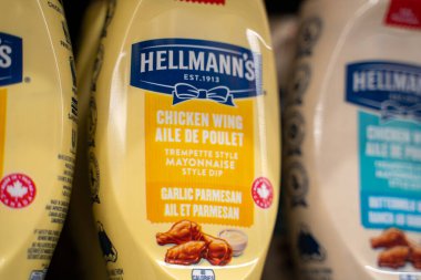Hellmann 'ın tavuk kanadı sarımsaklı parmesan şişelerini süpermarketin rafına koy. Toronto, Kanada - 26 Kasım 2025.