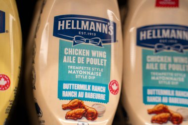 Hellmann 'ın tavuk kanadı tereyağlı çiftlik sosu şişelerini süpermarket rafına kapatın. Toronto, Kanada - 26 Kasım 2025.