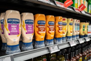 Hellmann 'ın sarımsak ve chipotle sosu şişeleri süpermarket rafında sergileniyor. Toronto, Kanada - 26 Kasım 2025.
