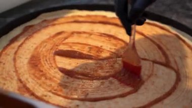 Taze pizza hamuruna domates sosu dök.