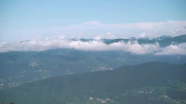 Sisli havada dağdaki bulutların ve ağaçların görüntüsü
