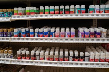 Raflara dizilmiş çeşitli akrilik boya şişeleri. Toronto, Kanada - 3 Aralık 2025.