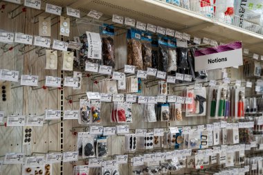 Bir mağaza duvarında gösterilen çeşitli dikiş kavramları ve düğmeleri görünümü. Toronto, Kanada - 3 Aralık 2025.