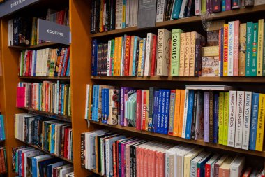 Raflarda renkli yemek kitaplarıyla yemek pişirme ve kitap yapma bölümünün manzarası. Toronto, Kanada - 3 Aralık 2025.