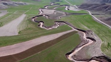 Uçsuz bucaksız topraklardaki tarlalarda akan nehrin havadan görünüşü.