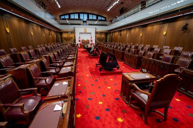Kanada Senatosu 'nun bayraklarla ve oturma yerleriyle iç mekan manzarası. Ottawa, Kanada - 15 Aralık 2025.