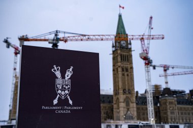 Arka planda parlamento binası olan Kanada Parlamentosu işareti. Ottawa, Kanada - 15 Aralık 2025.