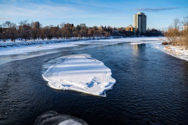 Kış boyunca Ottawa 'da kısmen donmuş Rideau Nehri manzarası.