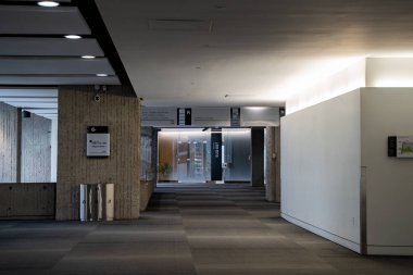 Beton sütunlu modern ofis koridoru manzarası.