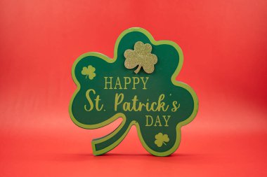 Kırmızı arka plandaki Mutlu Aziz Patrick Günü yonca tabelasını kapat.