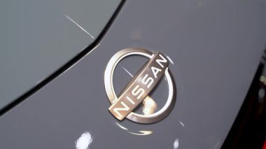 Gri araba yüzeyindeki Nissan amblemini kapat. Toronto, Kanada - 19 Şubat 2026.