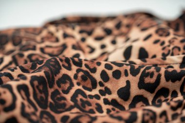 Yumuşak kıvrımlı ve desenli leopar desenli kumaşı kapat.